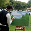 Live painter providing entertainment for elegant outdoor wedding event setting